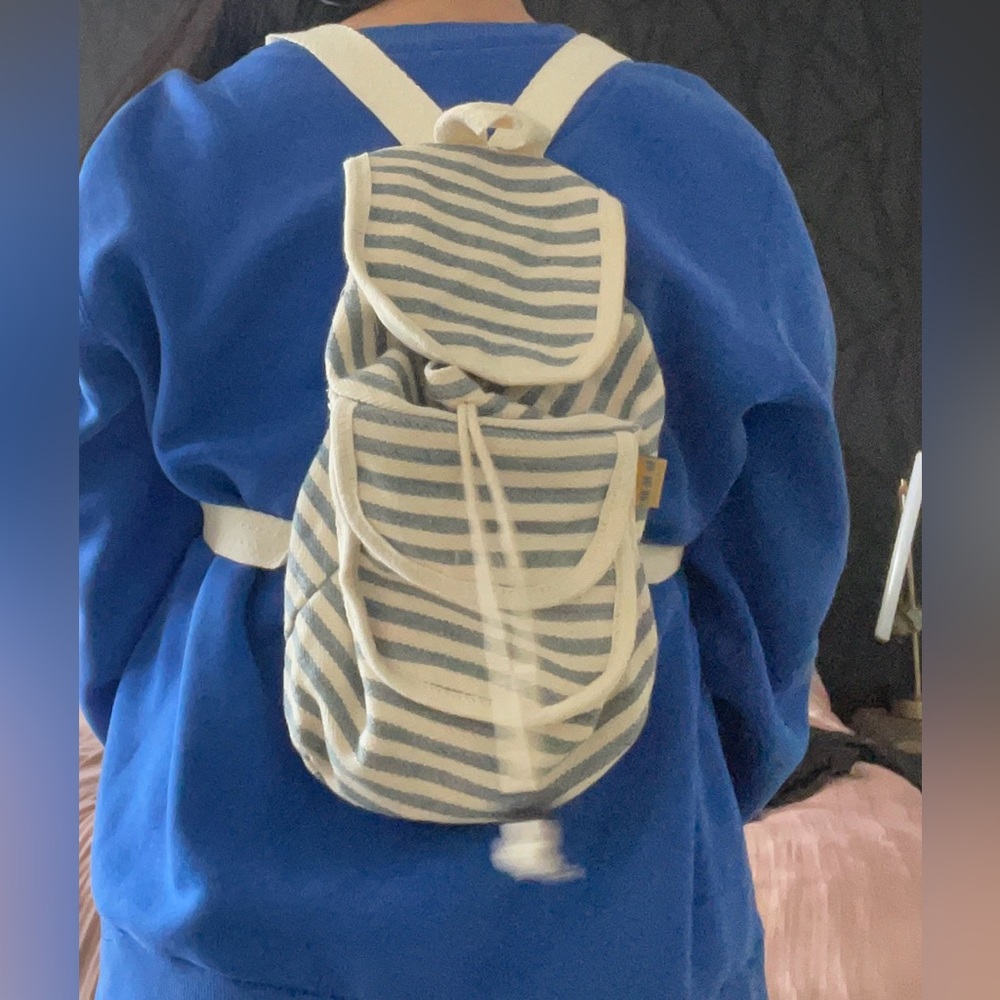 Striped blue and cream backpack with small zip pocket in front. - Picture 3 of 6